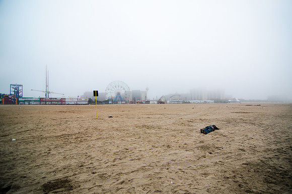 A man sleeps off the previous night on the Coney Island Beach - as Hurricane Irene gets closer.
